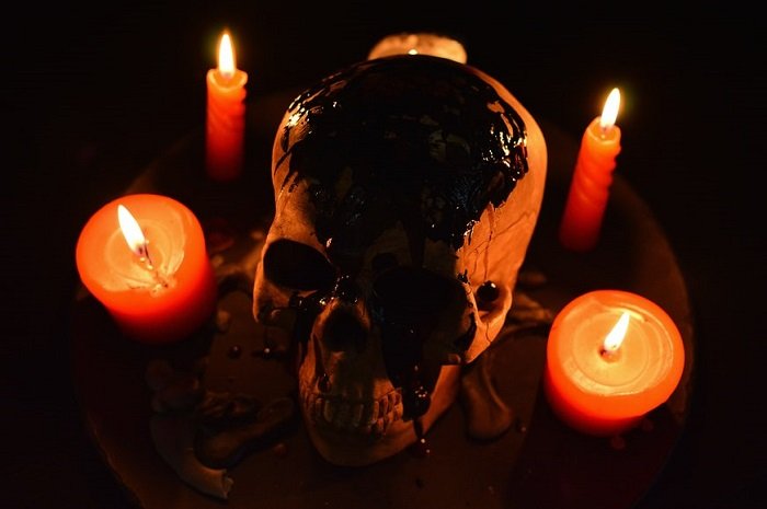 horror photography idea: a blood covered skull surrounded by 5 orange candles