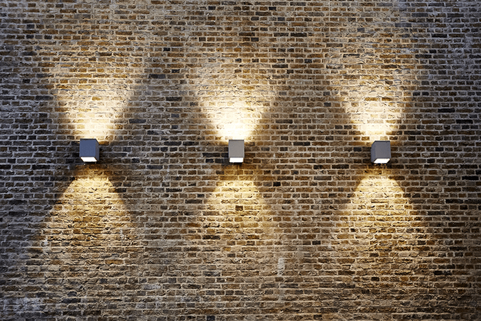 pattern in photography: three light fixtures against a brick wall 