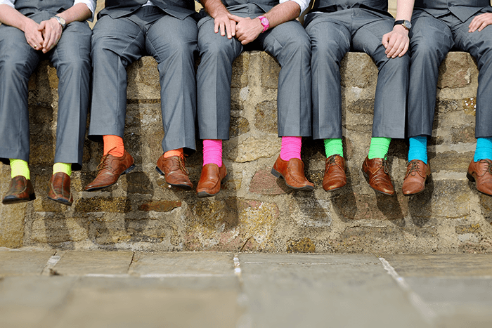 groomsmen picture idea: below the waist of a group of groomsmen wearing colourful socks