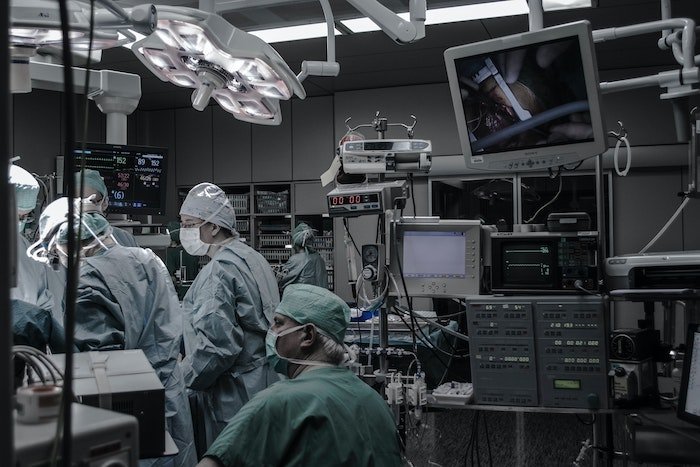 medical photography: An operating room with medical staff and surgeons in green scrubs and masks