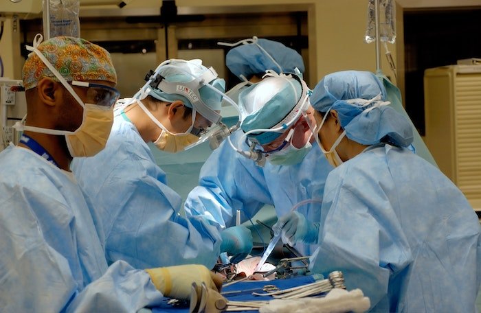 medical photography: Surgeons in blue scrubs and masks performing surgery in an operating room