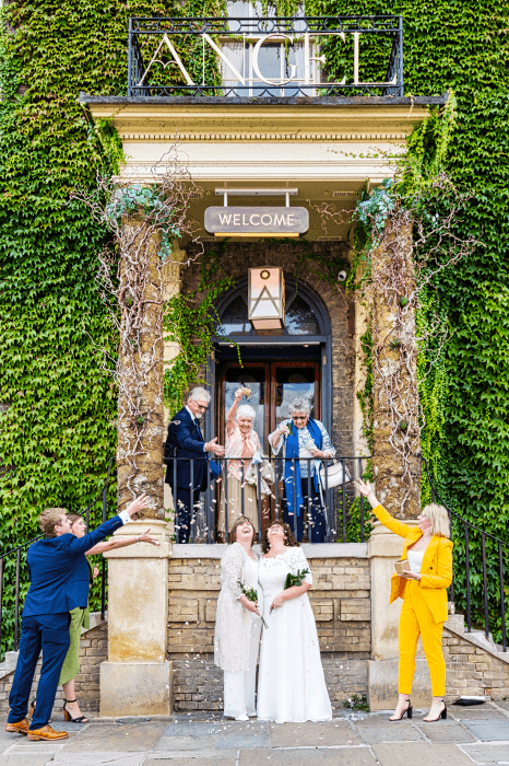 wedding shot: Confetti thrown over happy couple outside nice hotel