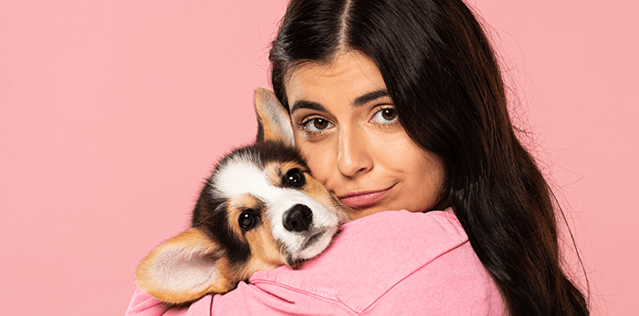 cute puppy photo tip: an image of a woman in pink holding her puppy against a pink background