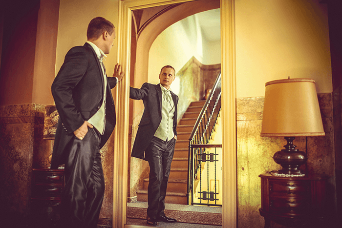 groomsmen picture idea: an image of a groom looking at his reflection in the mirror
