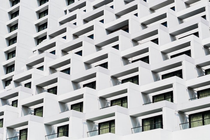 Photography detail of repeating windows and balconies on a white building