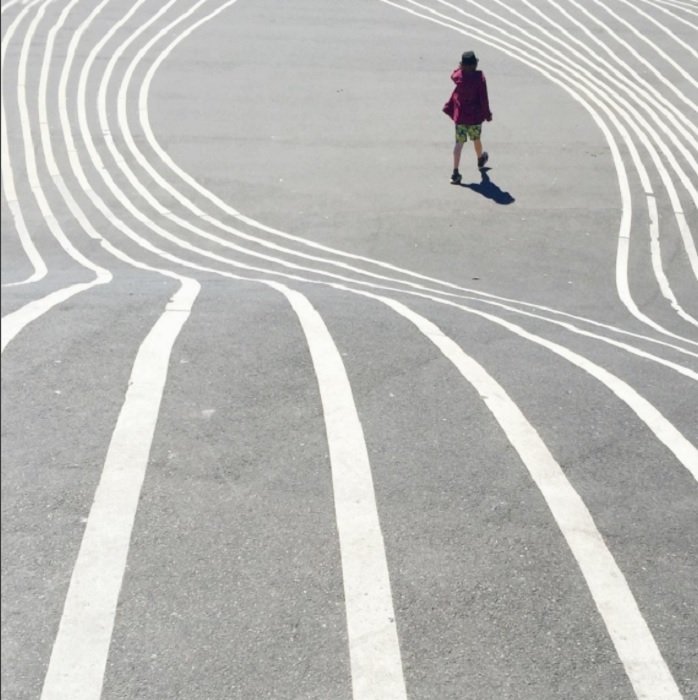 A person standing on concrete with wavy white lines surrounding here