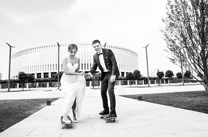 a black and white image of a skateboarding bride and groom