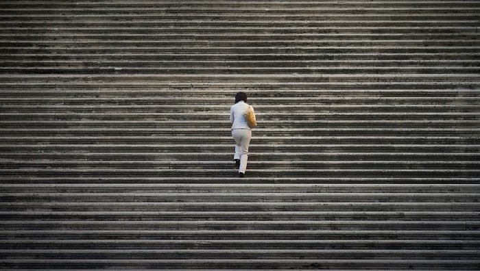 staircase photo idea: woman climbing up wide stone steps