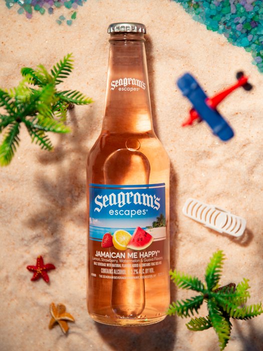 Flat lay product photography image of a beer bottle on a miniature beach background