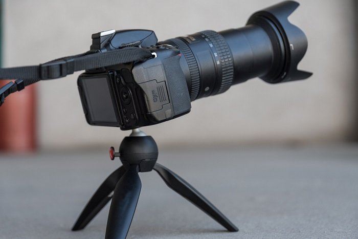 best mini tripod: the Manfrotto PIXI EVO holding a DSLR with a telephoto lens