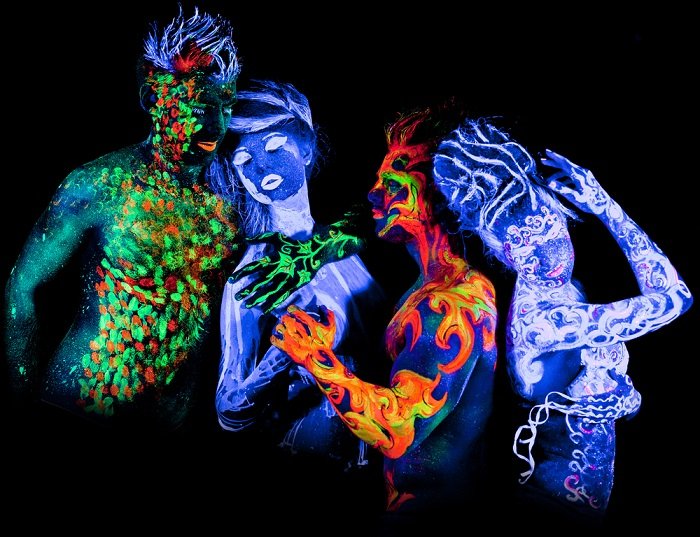 black light photography tips: four people covered in UV body paint interacting with each other