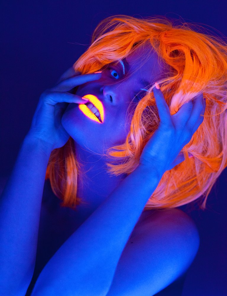 black light photography tips: portrait of a woman with UV lipstick and wig shot in UV light