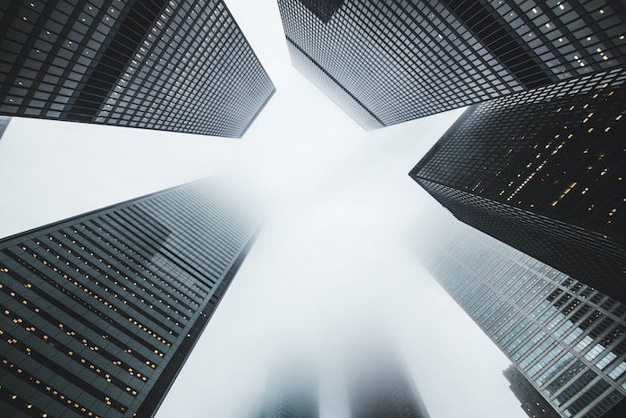 Office buildings rising into a blurred foggy sky