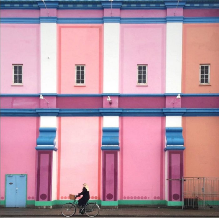 color block photoshoot ideas: a building painted with different shades of pastel reds and pinks 