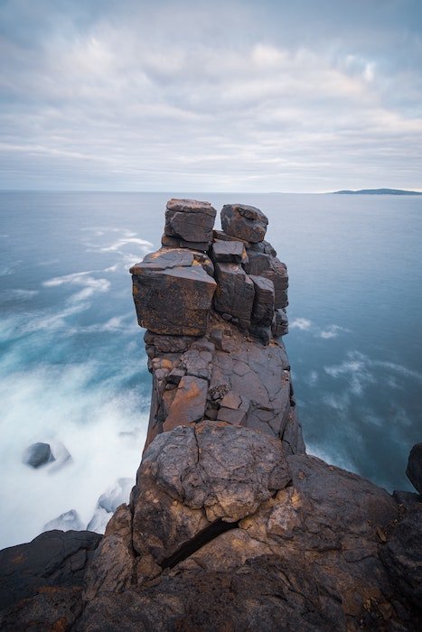 A landscape image of a rock cliff by a body of water for composite photography