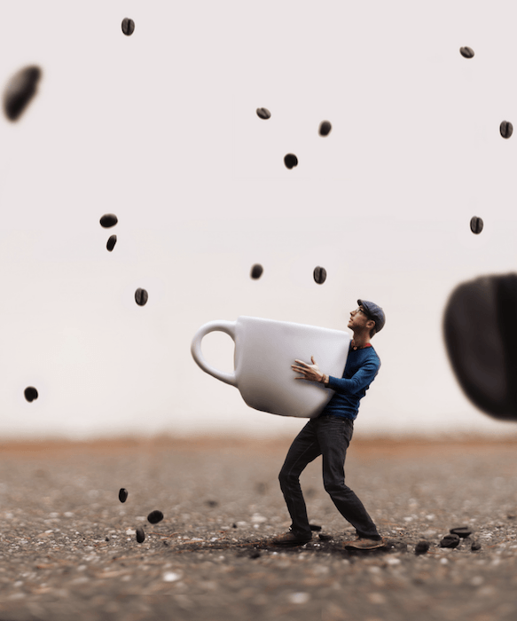 Composite photography image of a man holding a cup with coffee beans falling like rain around him