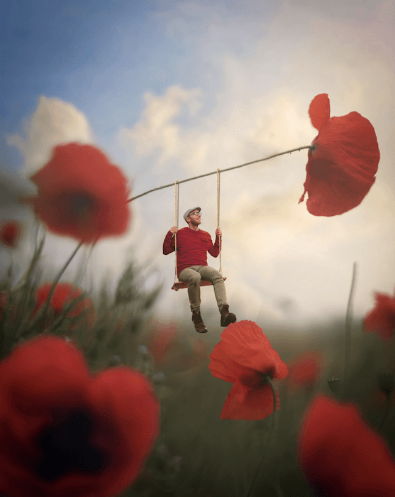 Photography composite of a man sitting on a swing attached to a poppy stem