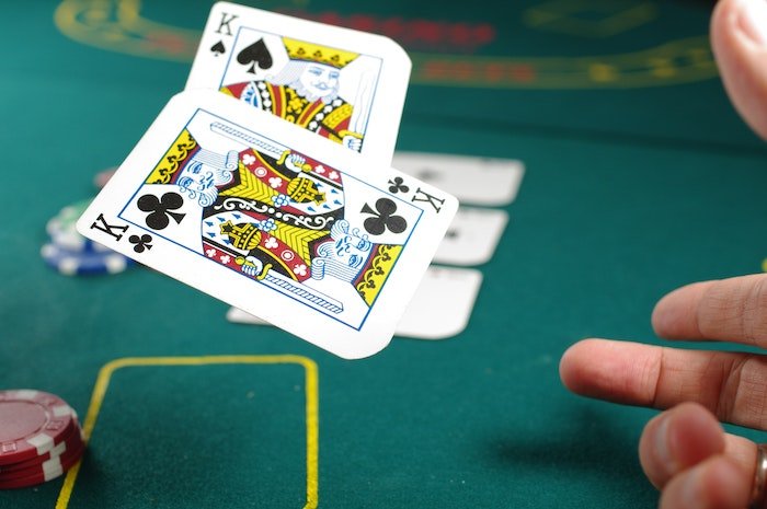 motion photographed: A pair of king playing cards being thrown onto a table for poker