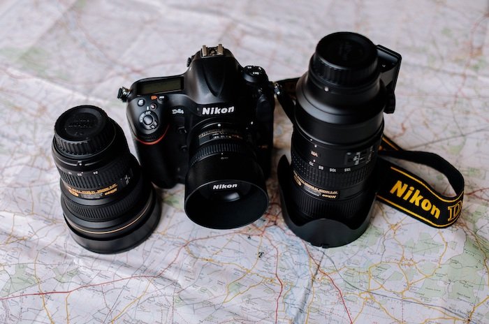 Nikon Lens Abbreviations: Nikon camera and two extra lenses sit on a map