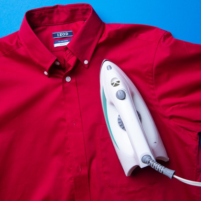 Flat lay photo of an iron on a red collared shirt