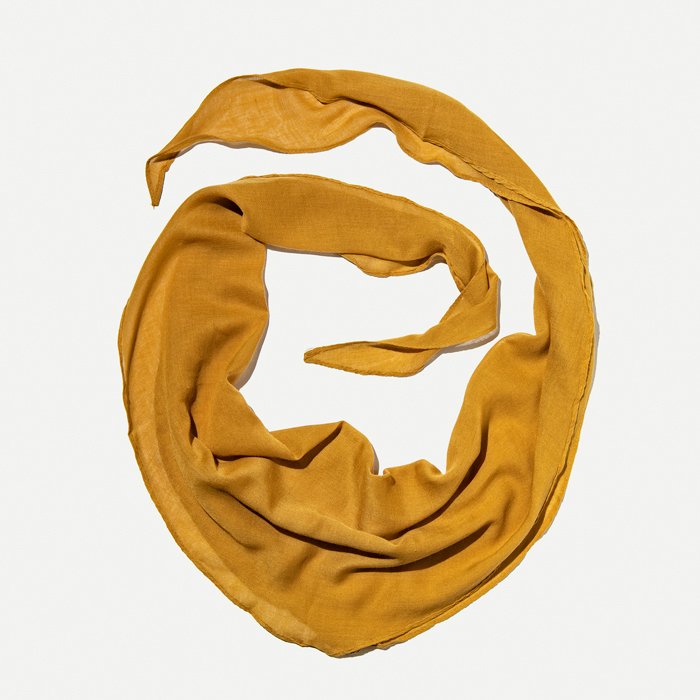 Flat Lay Photography of Clothing: A flat lay image of a mustard scarf laid out in a circular pattern