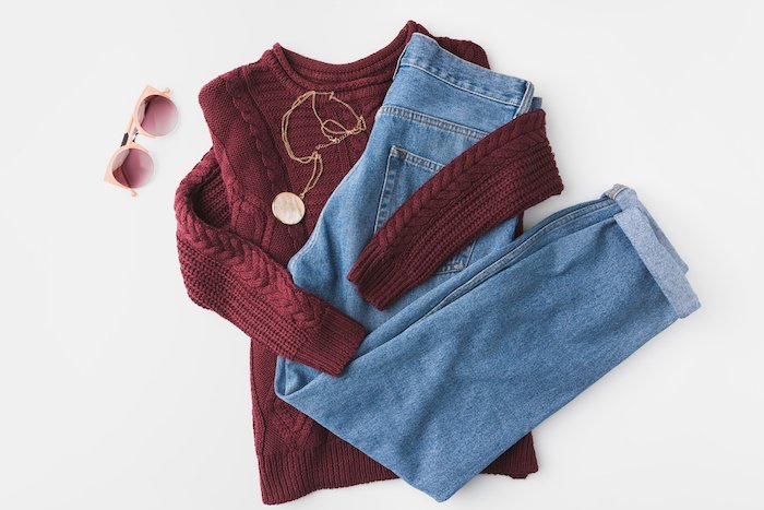 Flat lay photo of knitted sweater trendy jeans and accessories