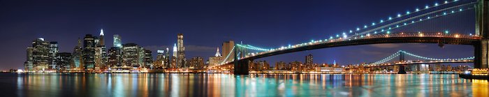 photo stitching: New York City Manhattan skyline panorama with Brooklyn Bridge and office skyscrapers building in at dusk illuminated with lights at night
