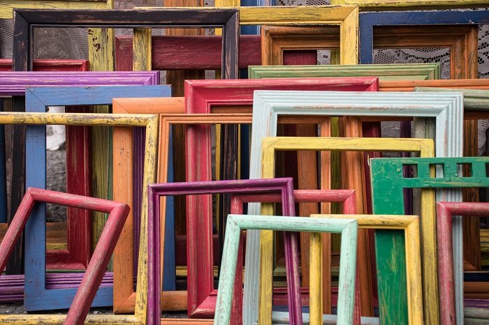 a group of colourful empty picture frames leaning against each other