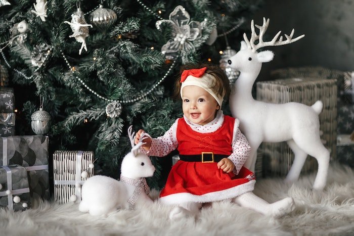 Baby in Santa outfit and with reindeer statues for Christmas card photo ideas