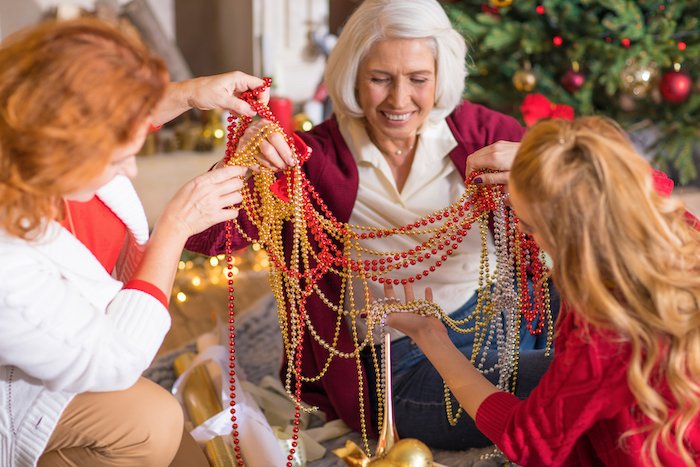 Family members untangling tree decorations for Christmas card photo ideas