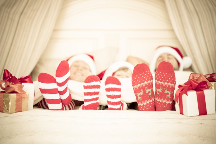 Christmas socks and presents a the end of a bed for Christmas card photo ideas