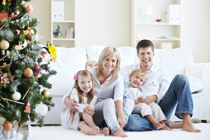 Family portrait by decorated tree for Christmas card photo ideas