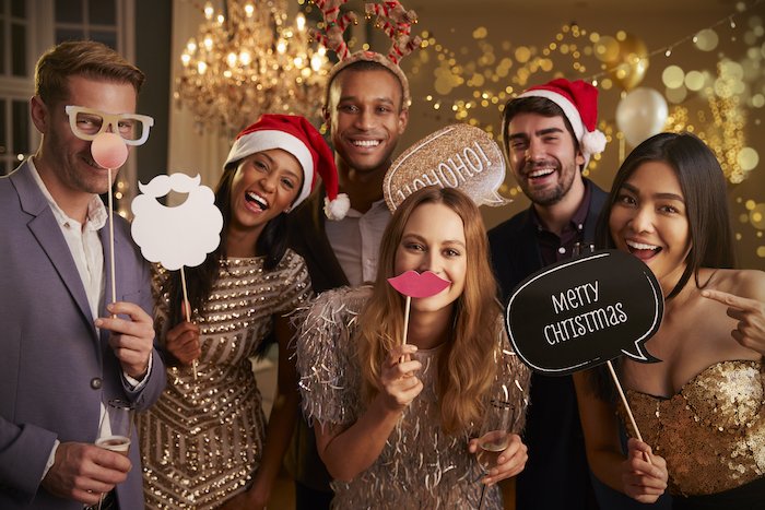Group photo of friends holding up props and signs for Christmas card photo ideas