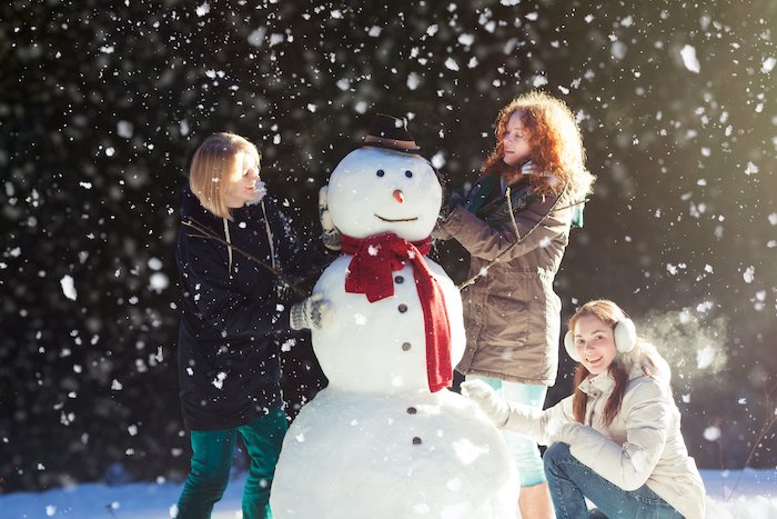 Building a snowman with family for Christmas card photo ideas