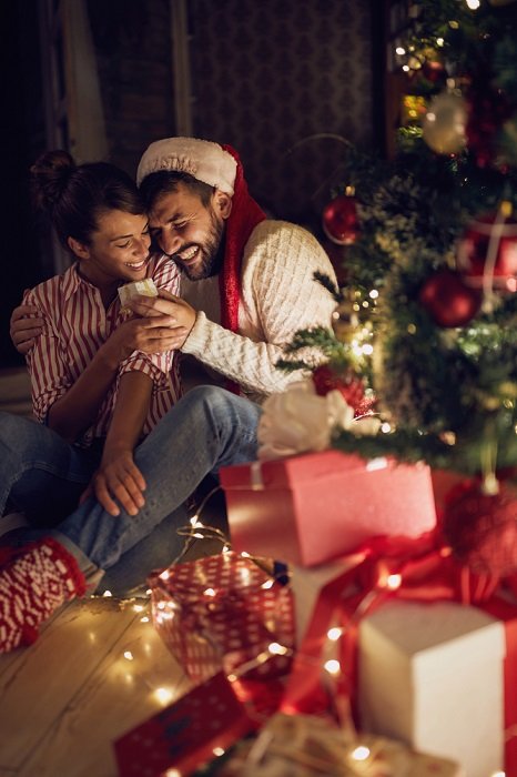 photo of a couple that shares a moment of joy next to the Christmas tree