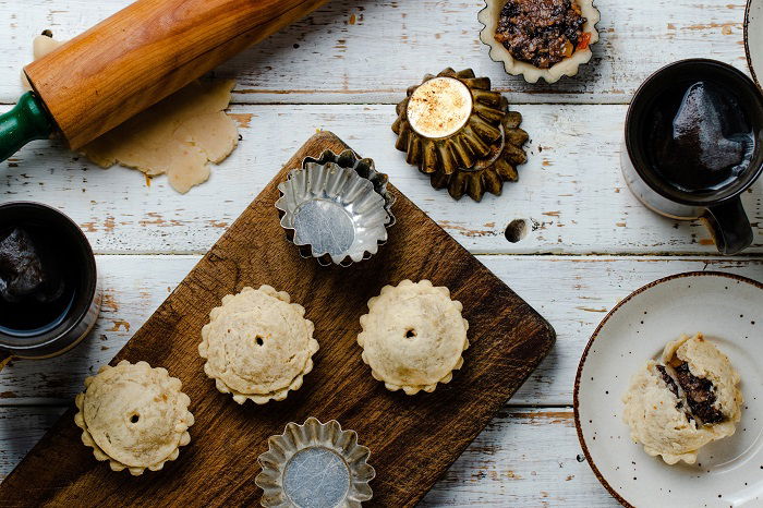 Tart on a wood cutting board and in tins used as food photography props