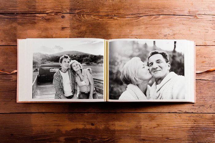 album with black-and-white pictures of senior couple on wooden background for photo gift ideas