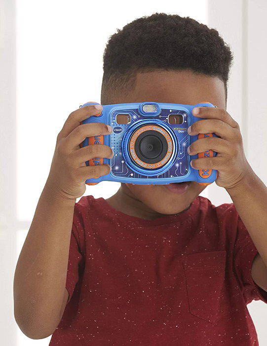 a young boy uses his camera to take a photograph of the person taking a photo of him