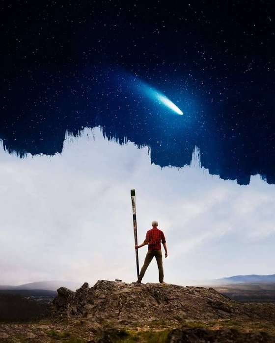 A composite image of a man holding giant paint brush with clouds and clear night sky