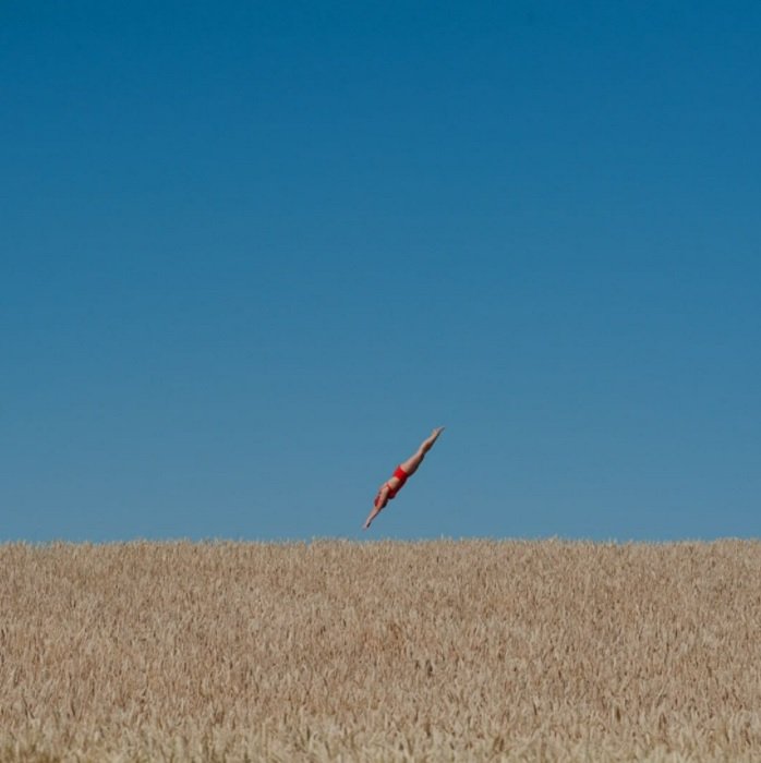 A composite image of a woman diving into a wheat field 