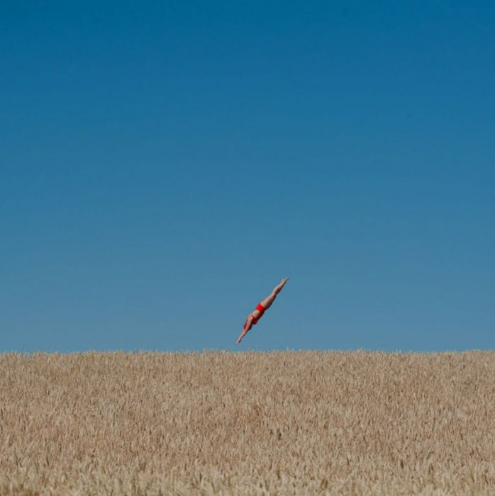 A composite image of a woman diving into a wheat field 