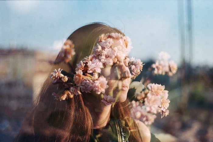 Double exposure maybe taken on film with a girls face being hidden amongst flowers
