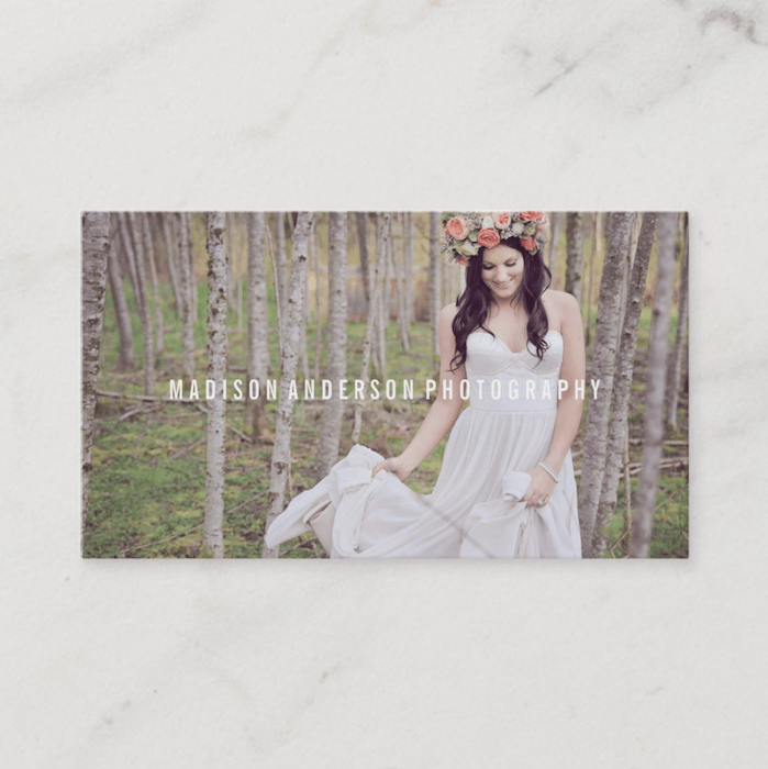 photography business card designs where a bride is holding her dress in a forest