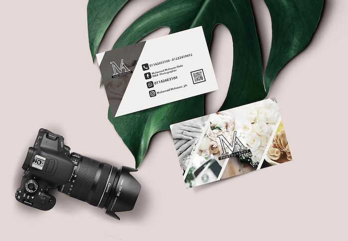 Photography business card designs where you can see a camera, a leaf and some business card on a pink background