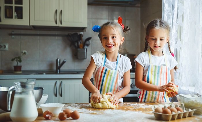 sister photoshoot ideas: Two girls cooking in kitchen