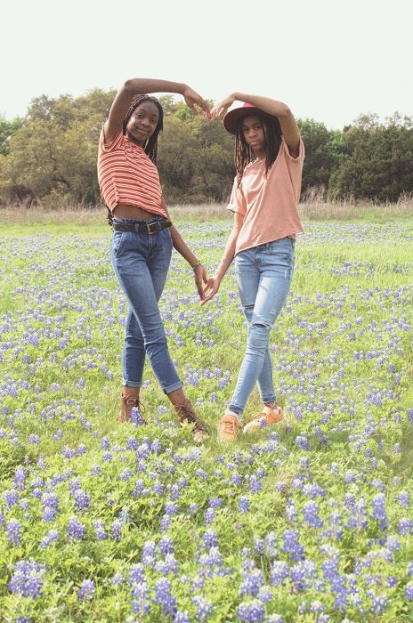 sister photoshoot ideas: Two Girls in a Meadow Making a Heart with Their Arms