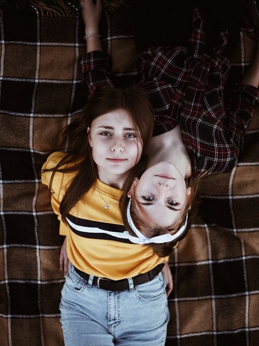 sister photoshoot ideas: two girls on a blanket photographed from overhead