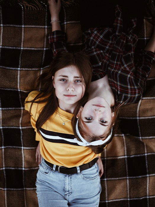 two cute long-haired young women sisters both in jeans and knitted sweaters  posing Stock Photo | Adobe Stock