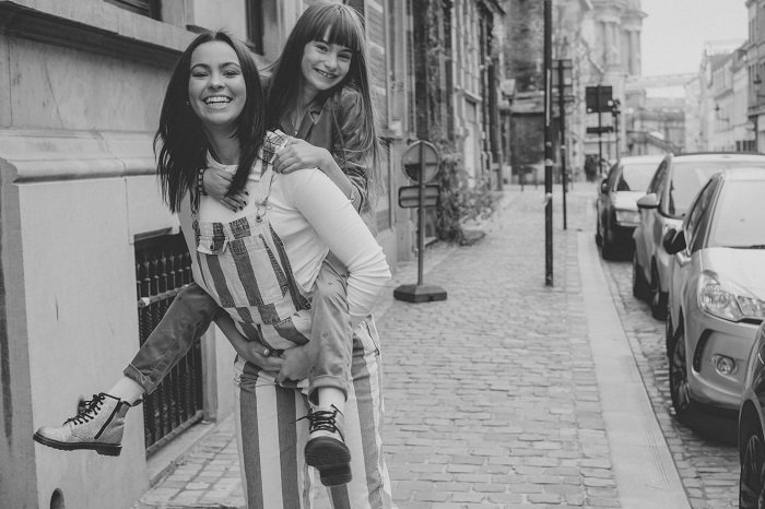 An older girl giving a younger girl a piggyback as a sister photoshoot idea