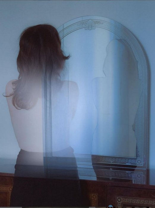 a surreal photography example from Anna Maghradze of a woman disappearing in front of a mirror